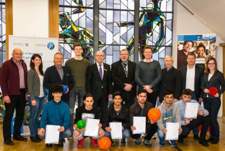 Gratulieren den sechs Schülern zur bestandenen Gruppenhelfer-Qualifizierung : (hintere Reihe, von links) Franz Berg (Stadtsportverband Büren), Julia Meier (KreisSportBund Paderborn), Diethelm Krause (Präsident KreisSportBund), Fabian Eßmann (KreisSportBund), Landrat Manfred Müller, Bernhard Lünz (Geschäftsführer Kommunales Integrationszentrum Kreis Paderborn), Falk Blöbaum (Ludwig-Erhard-Berufskolleg Büren), Hartmut Bondzio (Schul- und Sportamt Kreis Paderborn), Detlef Sandmann (Ludwig-Erhard-Berufskolleg Büren), Katrin Neumann (Kommunales Integrationszentrum Kreis Paderborn)  Haben die Ausbildung Gruppenhelfer International bestanden: (vordere Reihe, von links): Ahmed Anoor, Ahmed Sakka, Mohammad Aljouma, Nazir Nadari, Darwn Hama Sharif, Raafat Kabar © Amt für Presse- und Öffentlichkeitsarbeit, Kreis Paderborn, Anna-Sophie Schindler  Gruppenfoto